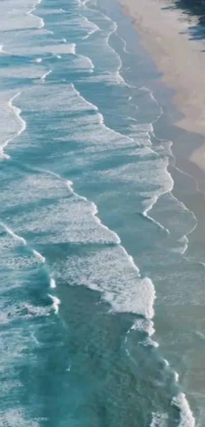 Aerial view of ocean waves meeting sandy beach.