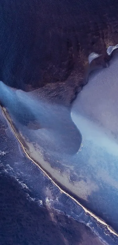 Aerial view of ocean with dark blue and white waves creating a serene pattern.