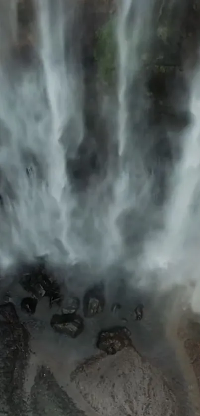 Aerial view of cascading waterfalls with misty atmosphere.