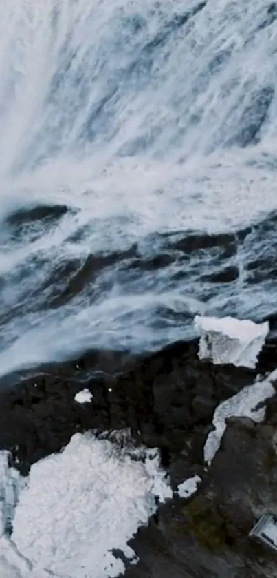 Aerial waterfall cascading over rugged cliffs in dramatic scenery.