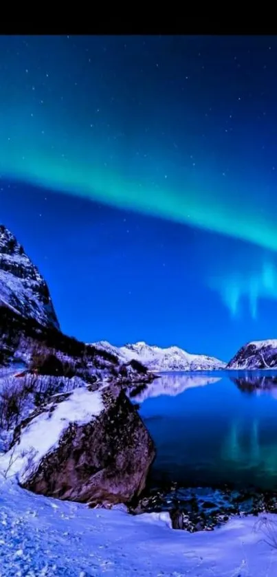 Aurora borealis over snow-capped mountains reflecting in a tranquil lake.