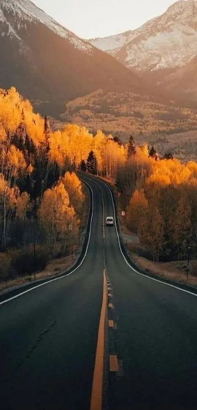 Scenic autumn road with golden trees and mountains.