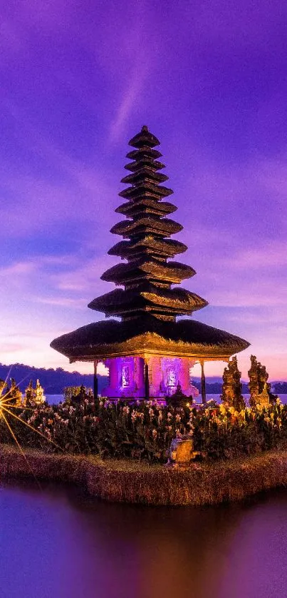 Balinese temple at dusk with purple sky and serene water reflection.