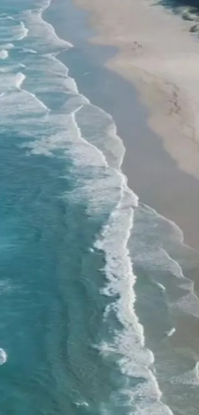 Aerial view of beach and ocean waves hitting the shore for mobile wallpaper.