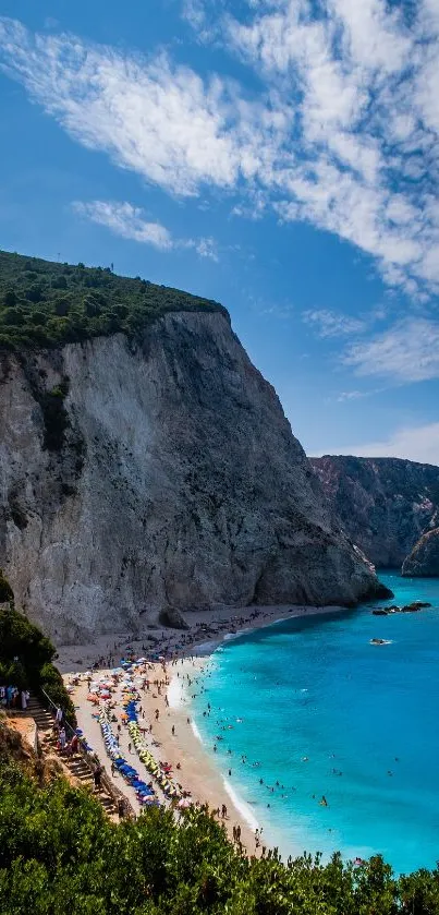 Breathtaking view of a beach with turquoise waters and imposing cliffs under a blue sky.