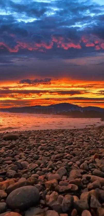 Beach sunset with vibrant colors over rocky shore.