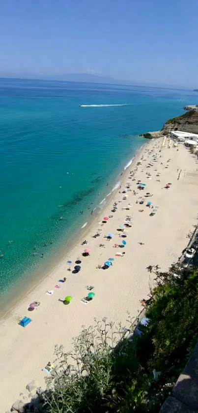 Overhead view of a beach with turquoise ocean and sandy shoreline.