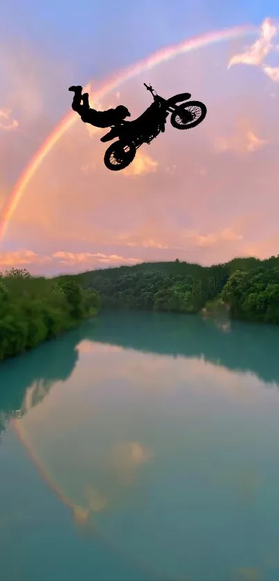 Biker silhouette under a rainbow with scenic river and lush greenery.