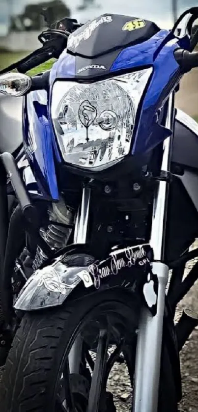 Close-up of a sleek blue motorcycle with a blurred road background.