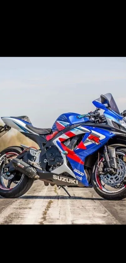 Blue sportbike on a road with scenic backdrop.