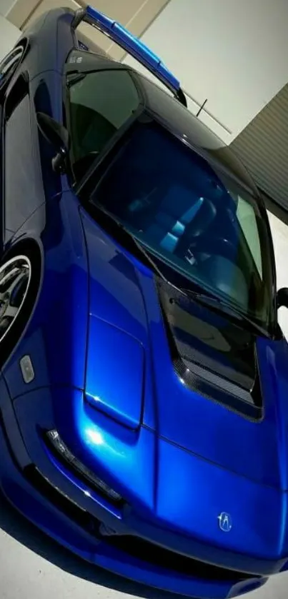 Blue sports car with sleek design on pavement.