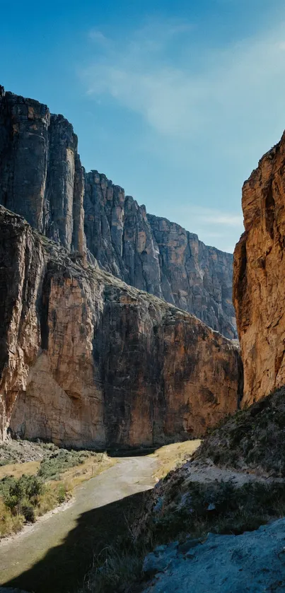 Majestic canyon wallpaper with towering rock formations and a blue sky.