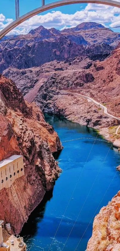 Canyon river and bridge under bright blue sky.