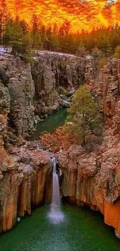 Vibrant canyon waterfall under a glowing sunset sky.