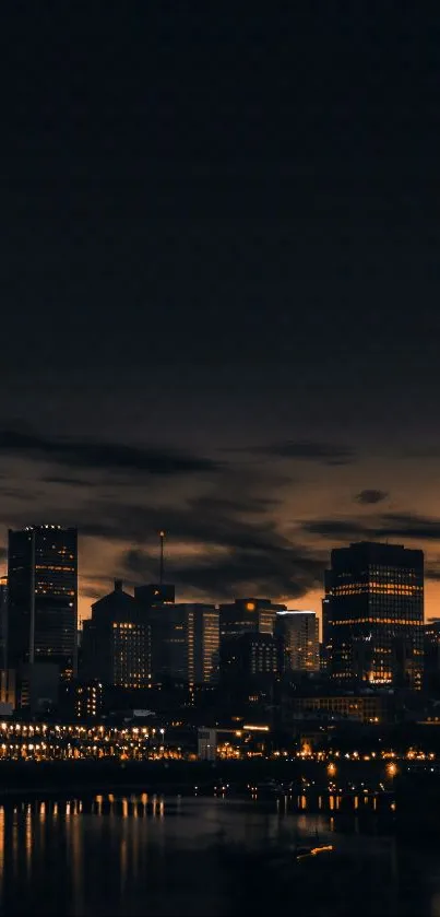 City skyline at night with lights reflecting on water.