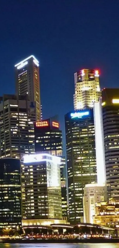 Night cityscape with illuminated skyscrapers reflecting on water.