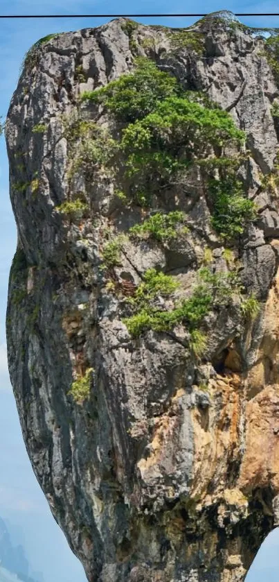 Tall cliff with greenery under a blue sky.