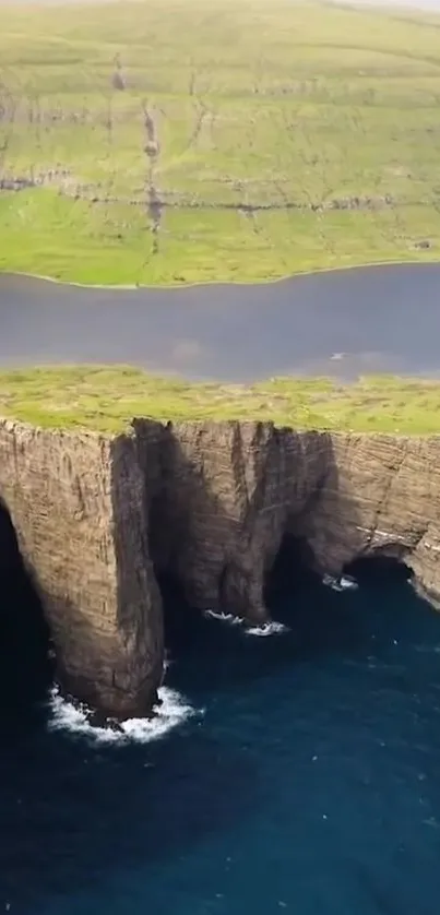 Majestic cliffs above a tranquil ocean with lush green landscape.