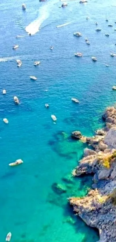 Aerial view of turquoise coastline with boats and rocky cliffs.