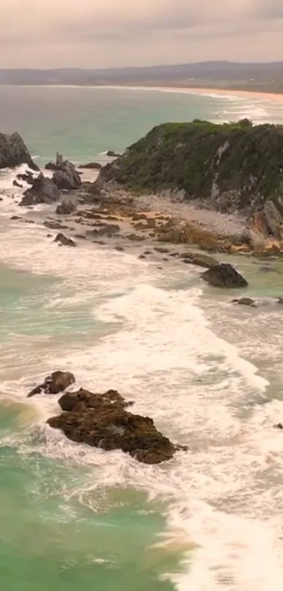 Turquoise coastal beach with waves and rocky cliffs.