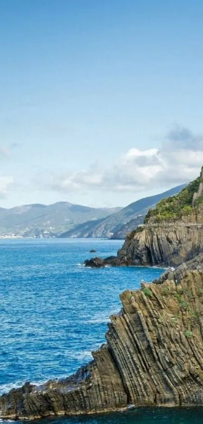 Coastal cliff and ocean view under blue sky.