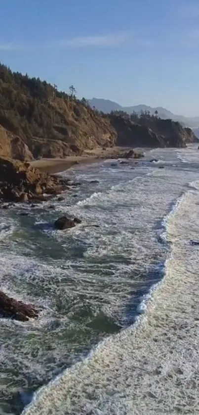 A stunning coastal ocean view with waves hitting the rocky shore under a blue sky.