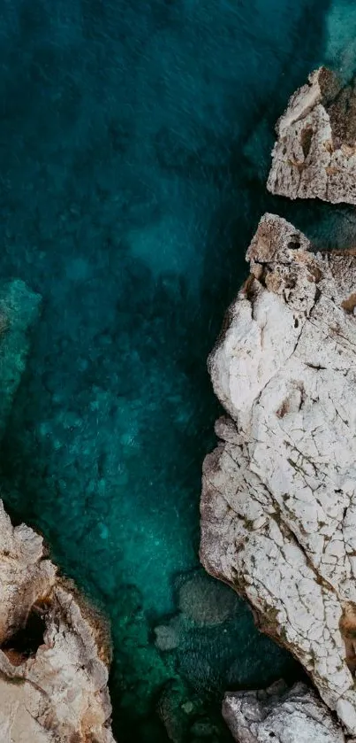 Aerial view of rocky coastline with teal ocean.