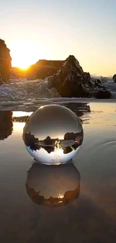 Sunset reflected in a glass sphere on a calm beach, creating a tranquil mobile wallpaper.