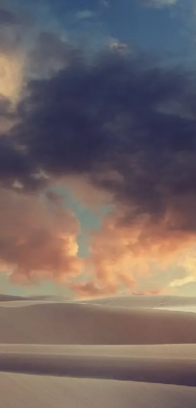 Desert sunset with vibrant clouds over sand dunes.