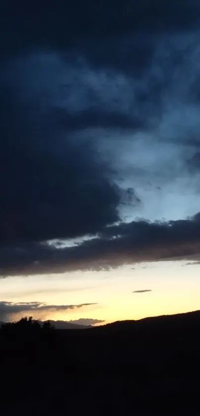 Dark evening sky with clouds and silhouette at sunset.