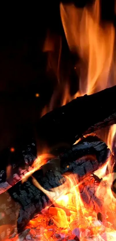 A mobile wallpaper showing burning firewood with vivid orange flames.