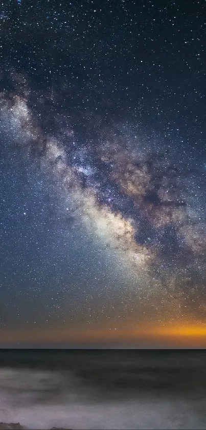 Galaxy over ocean under starry night sky.