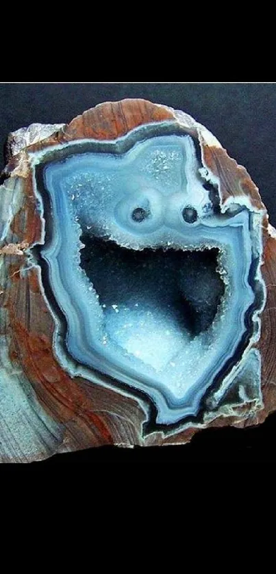 Brown geode with blue crystal center on dark background.