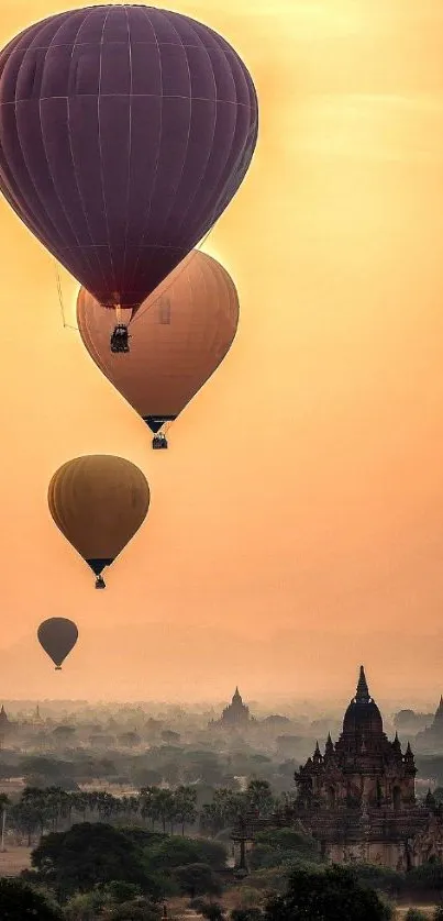 Majestic hot air balloons float over a temple at sunrise.