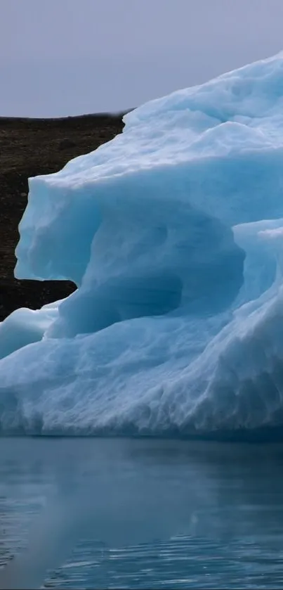 Serene iceberg with ice blue hues over calm water for mobile wallpaper.