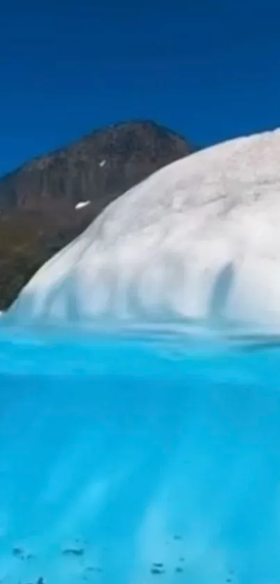 Turquoise glacier lake under blue sky with snowy mountain.