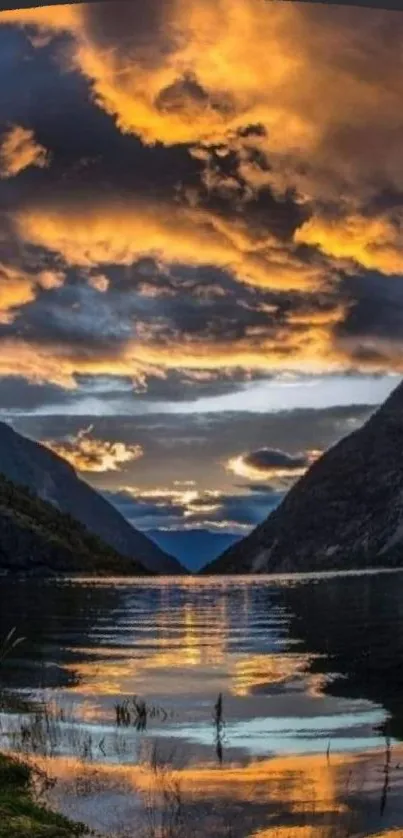 Lake at sunset with golden clouds and reflections on water, surrounded by mountains.