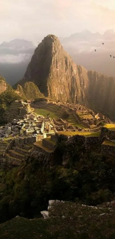 Majestic view of Machu Picchu with mountains and misty clouds on a mobile wallpaper.