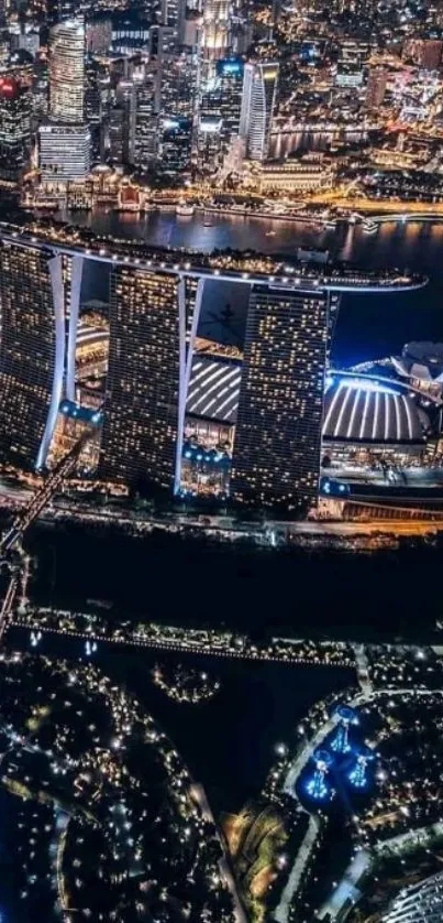 Aerial view of Marina Bay at night with illuminated buildings and skyline.