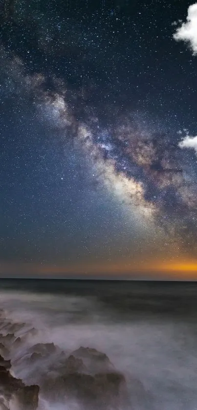 Milky Way and night sky over ocean with clouds.