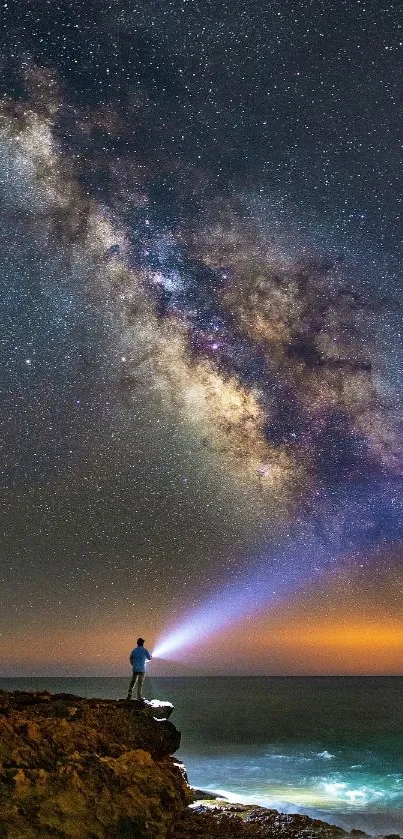 Person under a vivid Milky Way sky by the ocean.