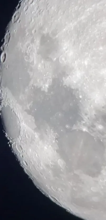 Detailed mobile wallpaper of the moon with craters against a dark sky.