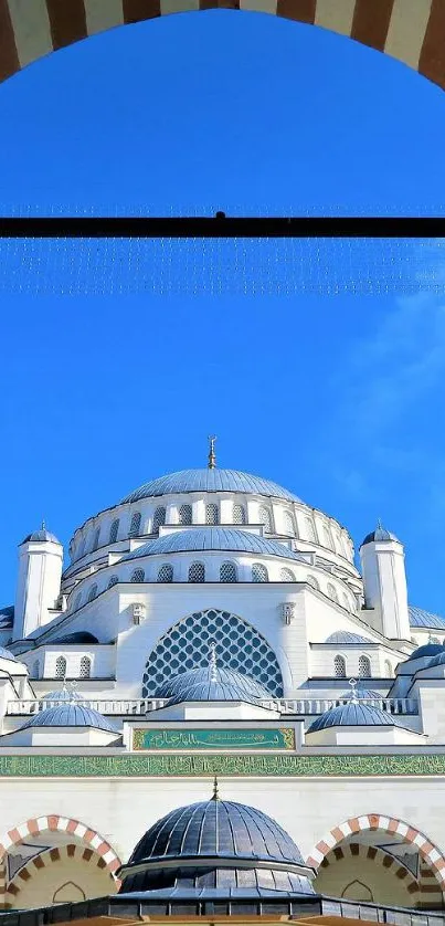 Elegant mosque architecture under a vibrant blue sky.