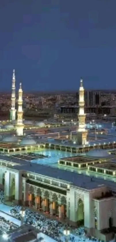 Mosque illuminated under a tranquil night sky with glowing minarets.