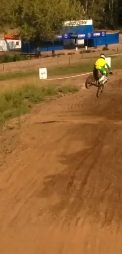 Motocross rider jumps on a dirt track, capturing thrilling action.