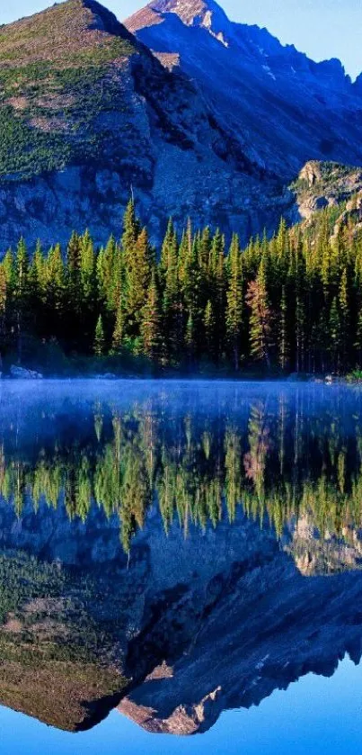 Mountain landscape reflected in a calm lake under a clear blue sky.