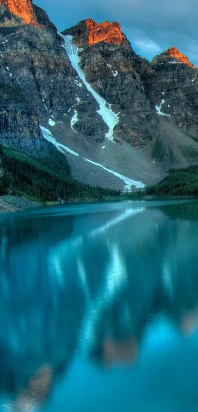 Majestic mountains reflecting in a serene blue lake at sunset.