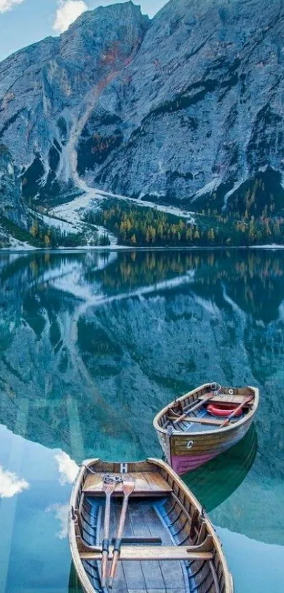 Serene mountain lake with wooden boats reflecting in clear blue water.