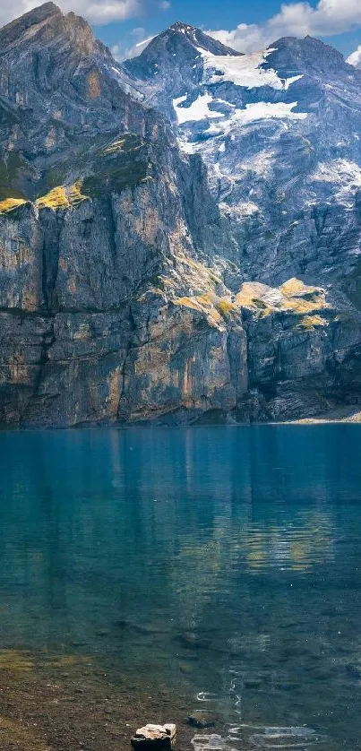 Serene mountain lake with clear blue water and towering cliffs.