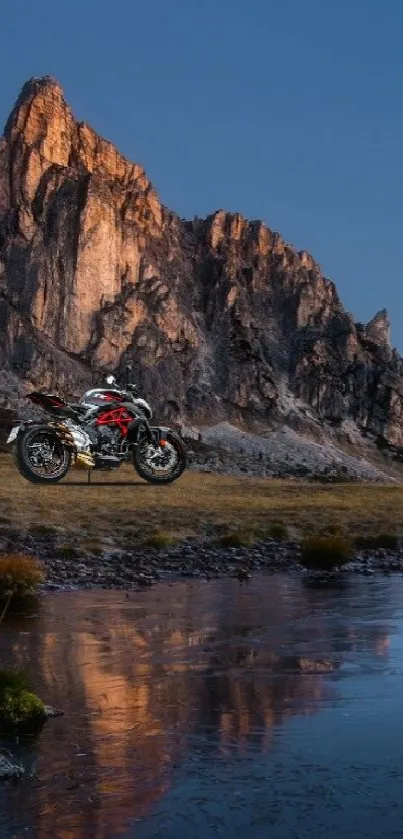 Motorbike by a serene mountain lake at sundown.